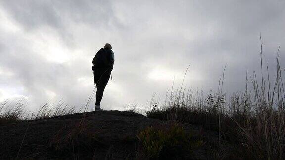 一名女子背着背包走过火山景观