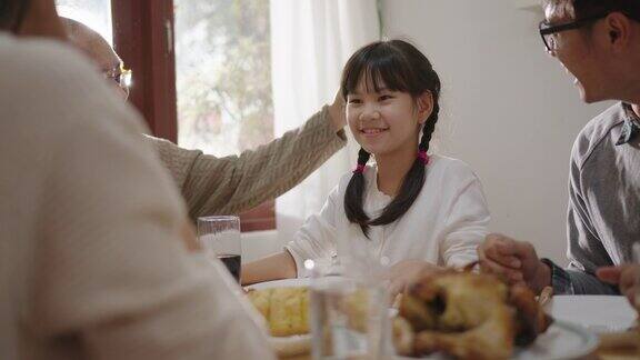 快乐的亚洲家庭共进早餐快乐的父母爷爷和可爱的女儿在家里的餐桌上一起享用早餐美妙的时刻家庭