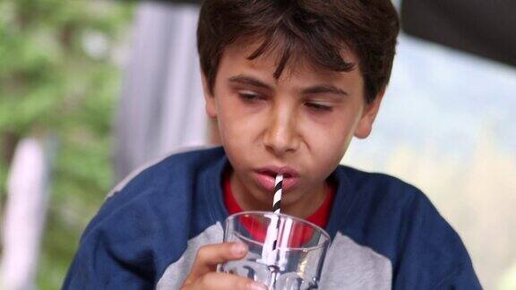 十来岁的男孩用吸管喝果汁