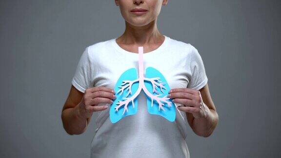 女士手持纸肺标志预防癌症和结核病保健