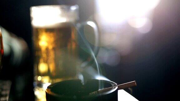 烟灰缸里的香烟酒吧桌上的啤酒