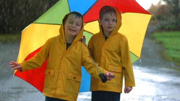 两个小男孩在雨中打着伞慢镜头