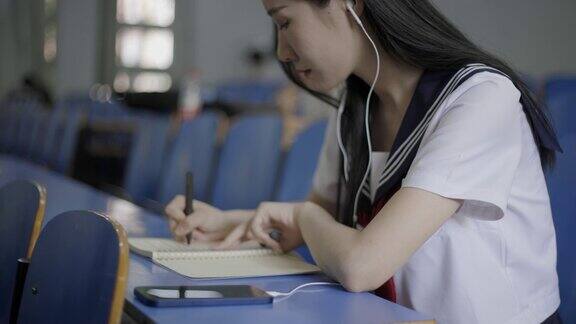 年轻的亚洲女大学生在教室里使用笔记本电脑