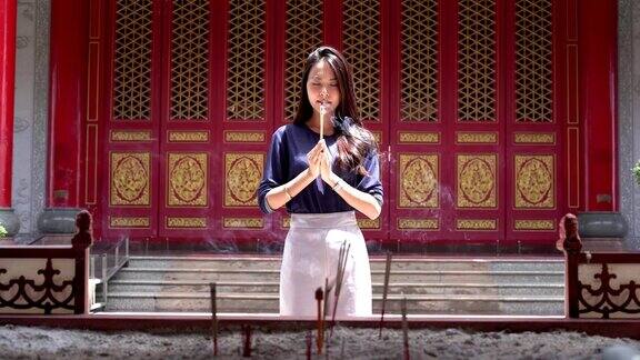 信奉佛教的亚洲妇女祈祷和点燃香