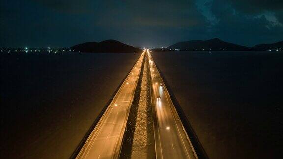 空中无人机HyperLapse或时间推移夜间到白天的场景交通车辆在跨越松卡湖廷素拉暖达桥沿着横跨泰国松卡湖的大桥