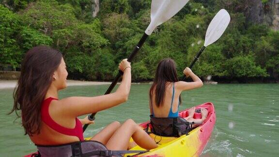 年轻的亚洲女性朋友们在暑假里一起在海里划皮艇