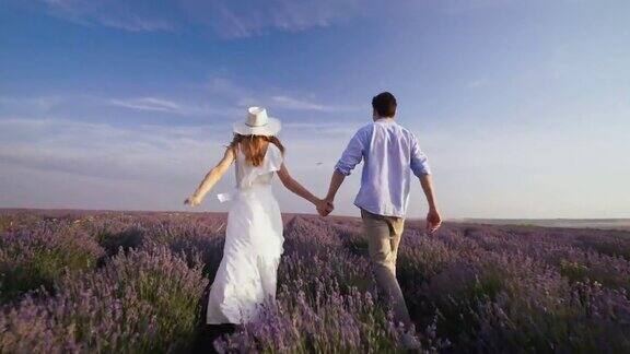 一对可爱的情侣手牵着手在薰衣草田里散步