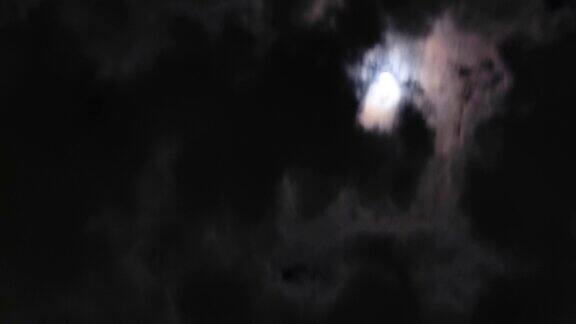 在夜晚云经过月亮明亮的满月与移动的云背景