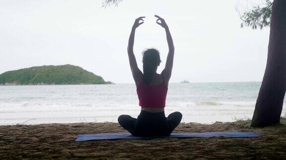 亚洲女人看海练练瑜伽在沙滩上冥想柔韧平衡瑜伽坐半莲花运动健康积极的生活方式理念