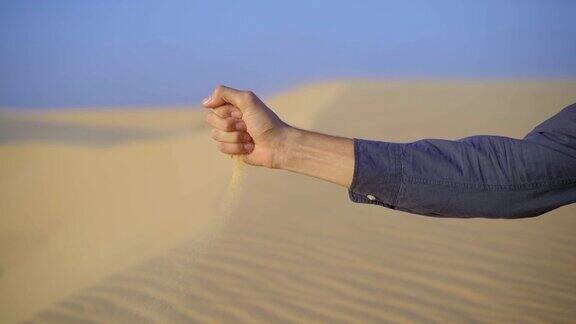 从一个男人的手中倒出的沙子的慢镜头