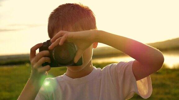 小男孩在拍摄他的妈妈站在湖边的傍晚日落