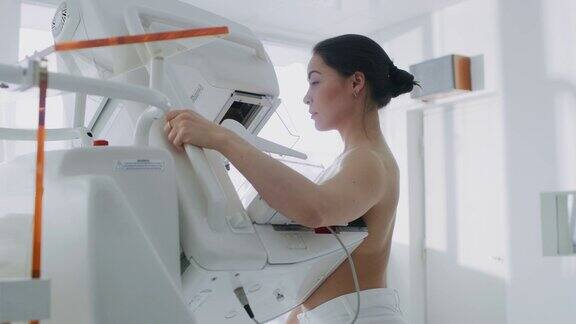 在医院里一名接受乳房x线筛查的半裸女性病人的肖像拍摄健康年轻女性进行癌症预防性乳房x线摄影扫描拥有高科技设备的现代化医院