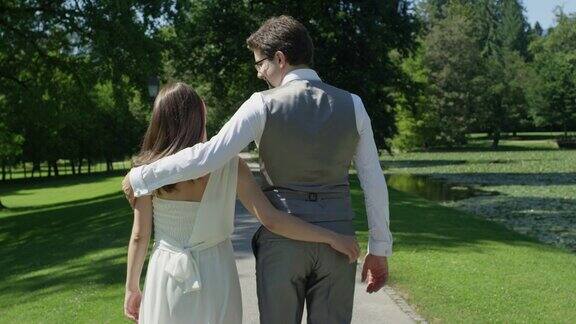 慢镜头:一对情侣在公园里散步手牵着手拥抱在一起