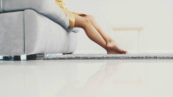 女人的腿走在地板上的灰色地毯上上面是蓬松的地毯现代风格