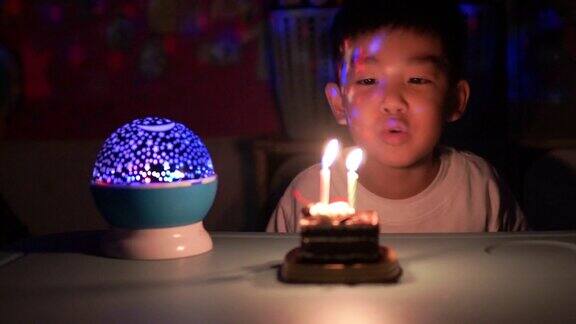 一个男孩通过吹蛋糕和唱生日歌来庆祝他的生日