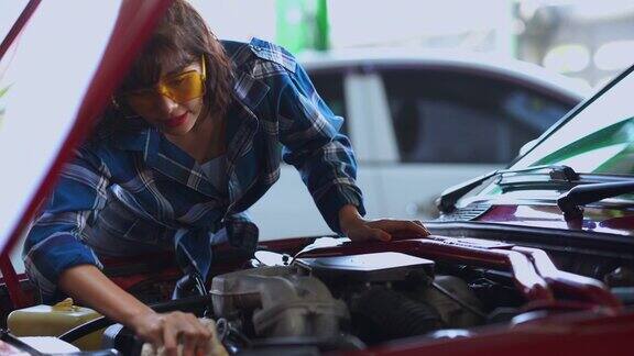 年轻的女技术员在车库里检查机油