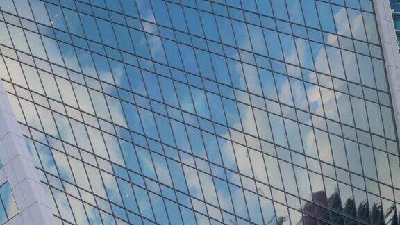 时间流逝-移动的白云在摩天大楼玻璃墙的反射