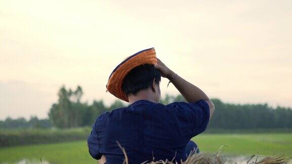 年轻的农民在田里种完稻子后擦汗
