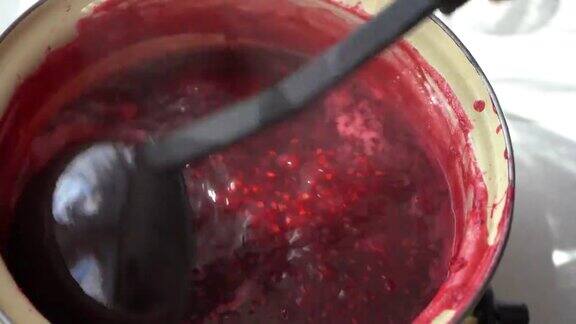 在厨房锅里做覆盆子果酱然后舀起来让树莓果酱