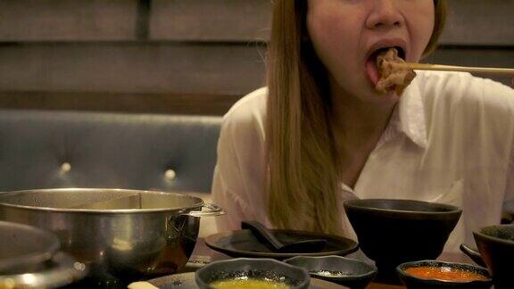 一位亚洲妇女正在吃日本和牛涮锅