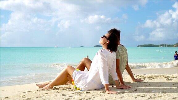 一对年轻夫妇在白色的海滩上度过暑假幸福的情侣们在异国的小岛上享受蜜月