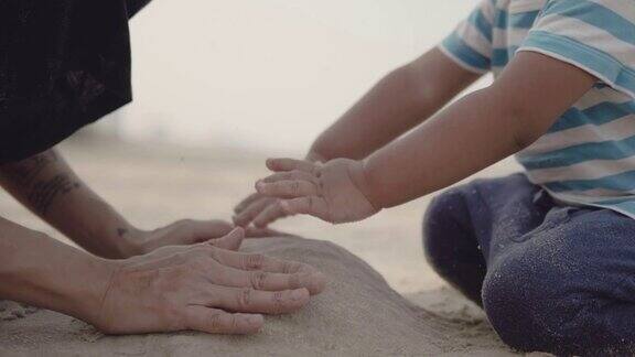 年轻的母亲和小男孩在沙滩上玩沙子