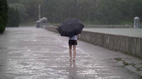 孤独的女孩在雨天撑着伞走在街上