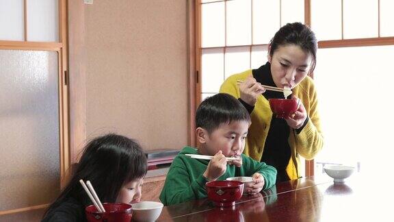 日本妈妈和孩子们在日本人的房间里吃麻糬、年糕