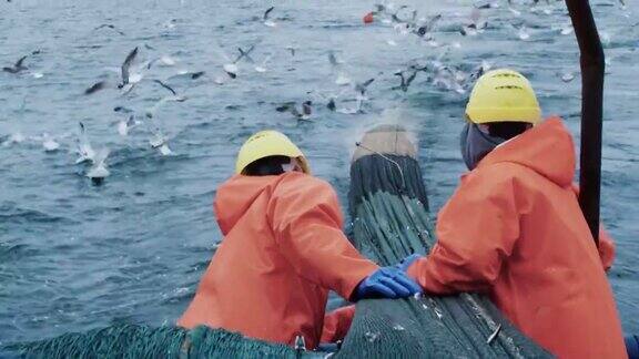 渔民在商业渔船上拖网捕鱼