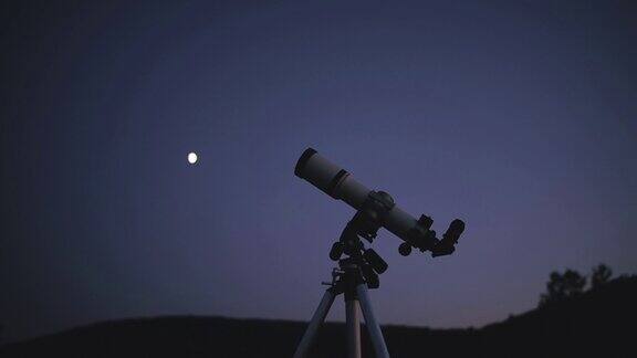 望远镜剪影在黑暗的月光天空在农村景观