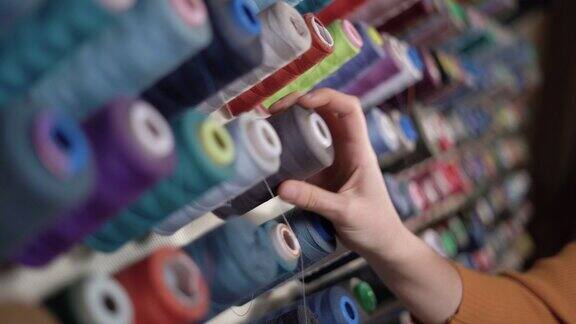 缝纫线轴上的线纺织厂的彩色线轴多色线女手放几卷