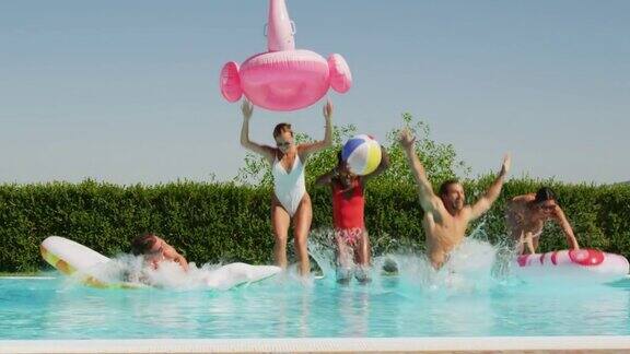 在阳光明媚的日子里身着泳装的年轻多民族朋友们在五颜六色的充气泳池里尽情享受暑假时光