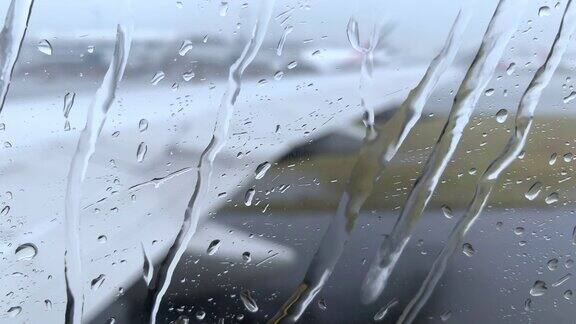 微距拍摄的雨下窗口的商业喷气客机由于天气恶劣航班延误起飞