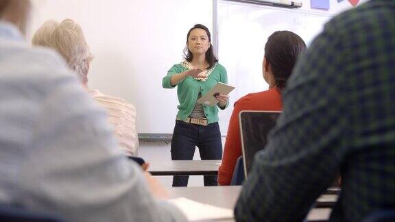 女性亚洲教师平板电脑上成人教育课