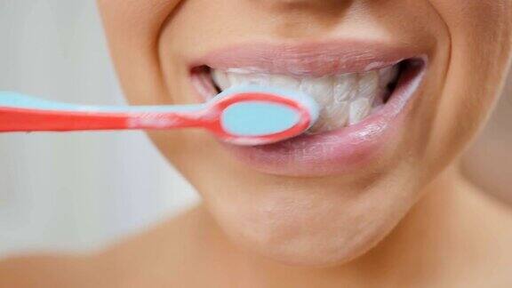 女人用牙膏和牙刷清洁牙齿
