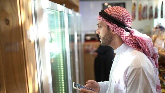 阿拉伯中东男子在便利店用手机购物