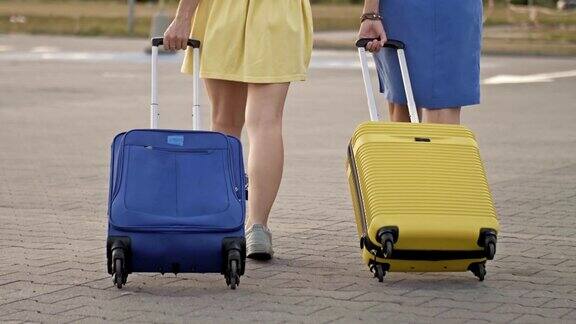 带着行李箱的乘客在火车站的站台上行走两个女人带着行李要去机场