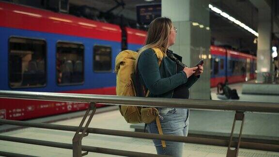 一位女士在等电车时使用手机