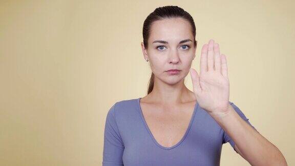 白种女性举手示意停止并挥舞手指表示不