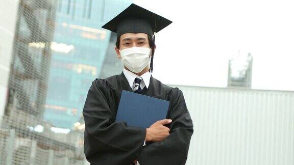 一幅亚洲学生的肖像戴着学士帽穿着学位服庆祝毕业
