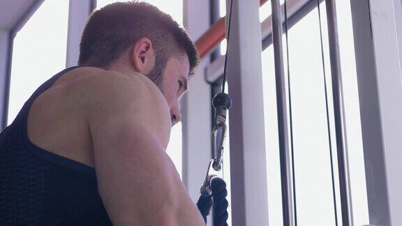 肌肉建设运动男性做力量锻炼的牵引模拟器同时在体育中心的健身房工作的身体