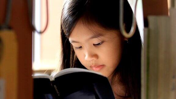 一个亚洲小女孩在图书馆看书