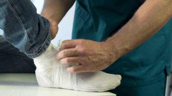 急救中心外科医生将石膏石膏贴在骨折病人的腿上