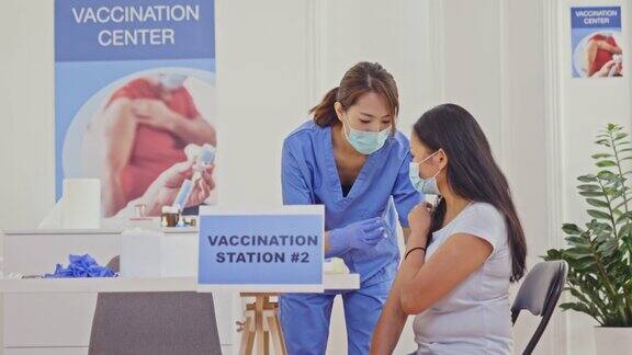医护人员在疫苗接种中心为妇女注射新冠疫苗