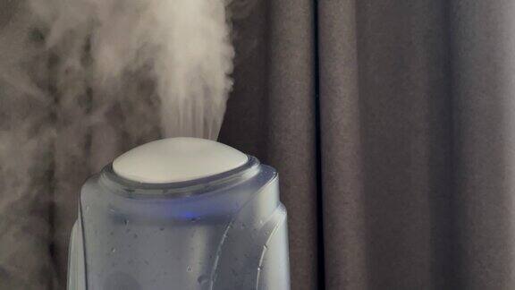 加湿器工作在灰色窗帘的背景上加湿器中的水雾蒸汽