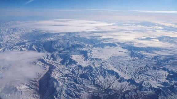远处的山脉从飞机窗口映入蓝天