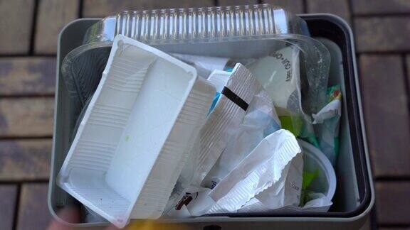 篮子在家单独收集塑料-垃圾从塑料食品容器扔进垃圾桶-拯救地球-走向绿色