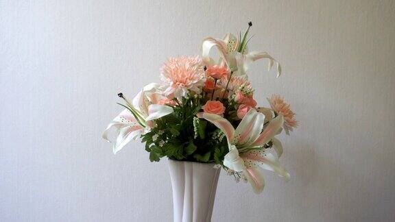 百合花玫瑰康乃馨花在粉红色的花瓶在白色的背景旋转粉彩花系列展示