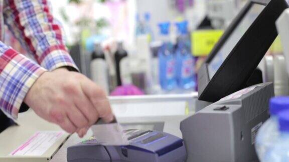 一个人在商店里通过终端机支付信用卡