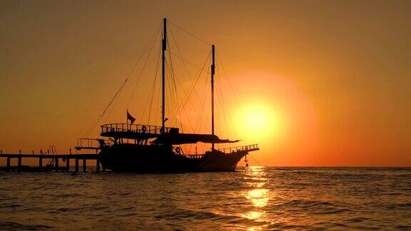 五颜六色的日落与帆船在海面上反射在水面上的太阳落日海洋海景夏日和旅游度假